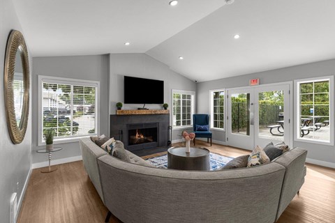 A living room with a grey couch and a fireplace.